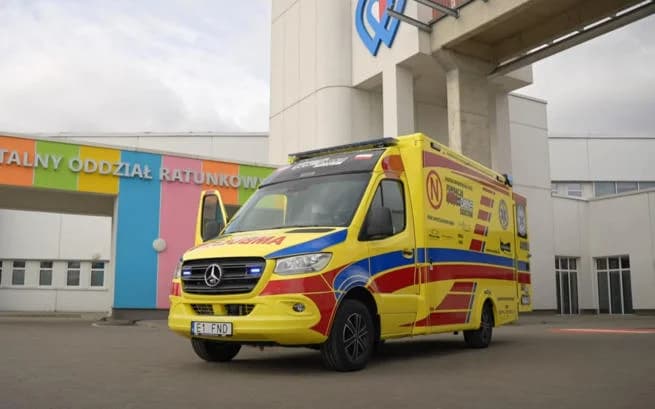 Żółta karetka neonatologiczna przed szpitalem